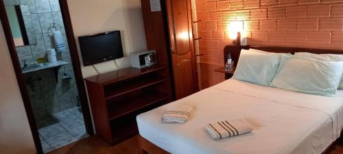 a bedroom with a bed with a shower and a television at hotel le Massilia in Belém