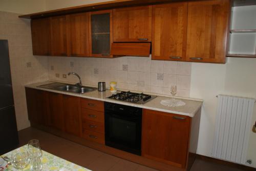 una cucina con armadi in legno, lavandino e piano cottura di Casa Anna Ponte di Brenta Padova Est a Padova