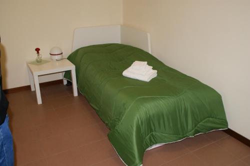 un letto verde in una stanza con tavolo di Casa Anna Ponte di Brenta Padova Est a Padova
