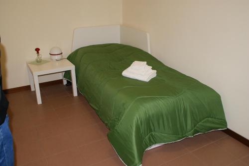 a green bed in a room with a table at Casa Anna Ponte di Brenta Padova Est in Padova