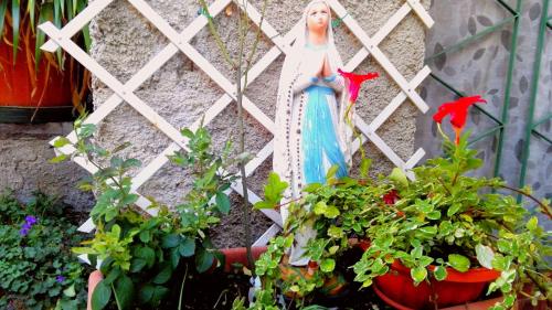 a statue of an angel sitting next to some plants at With Love in Malcesine