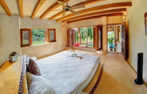 a large bed in a room with windows at Espectacular Troncones Estate with 360 degree Views - 5 minute walk from the main surf break in Troncones