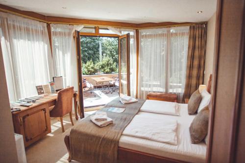 Schlafzimmer mit einem Bett, einem Schreibtisch und einem Fenster in der Unterkunft Provence rooms in Banja Luka