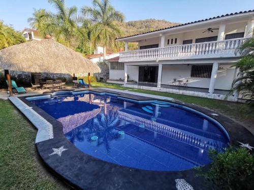 a swimming pool in front of a house at La Quinta de Don Hugo in Ixtapa