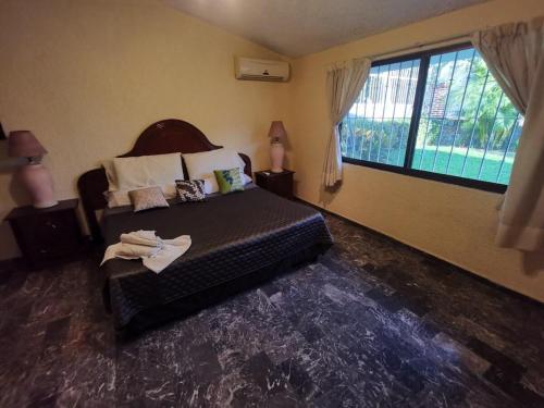 a bedroom with a bed and a large window at La Quinta de Don Hugo in Ixtapa