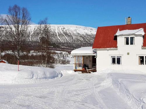 una casa blanca con techo rojo en la nieve en 6 person holiday home in Storsteinnes, en Storsteinnes