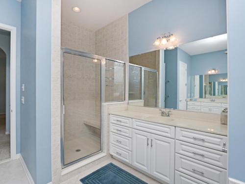 a bathroom with a shower and two sinks and a glass shower stall at Bayside Resort - 36477 Wild Rose in Selbyville
