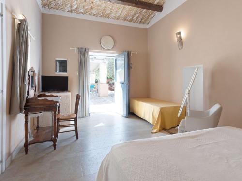 a bedroom with a bed and a desk and a computer at Farmhouse in Noto with Pool and Garden in Noto