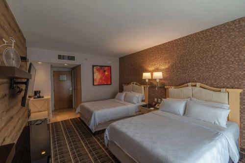 Holiday Inn Queretaro Centro Historico, an IHG Hotel tesisinde bir odada yatak veya yataklar