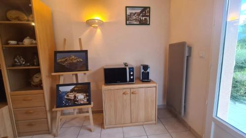 a kitchen with a microwave on a counter with a tv at Petite maison aux abords de Bagnères de Bigorre in Bagnères-de-Bigorre