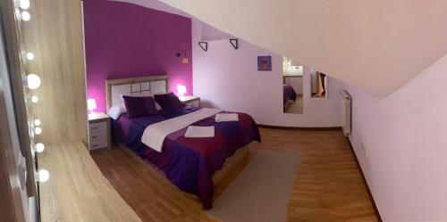 1 dormitorio con 1 cama con paredes moradas en Apartamento Isabela2, en Cangas de Onís