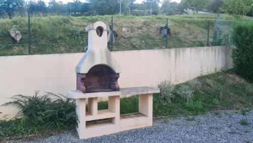 a brick oven sitting next to a fence at Petite maison aux abords de Bagnères de Bigorre in Bagnères-de-Bigorre