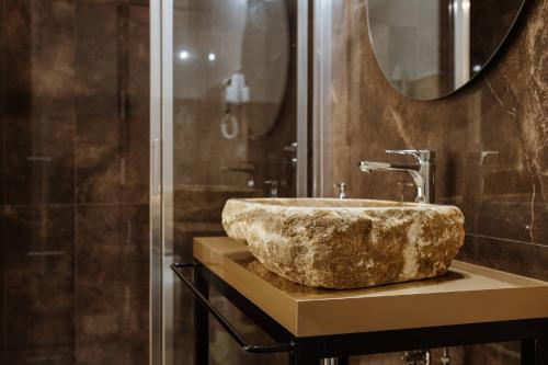 bagno con lavandino in pietra e doccia di BaroccoSuite a Lecce