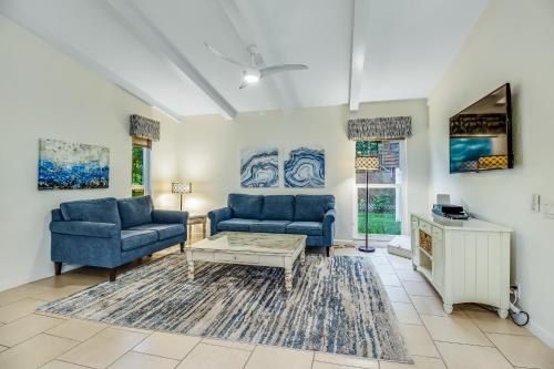 a living room with two blue couches and a coffee table at Au Soleil in Anna Maria