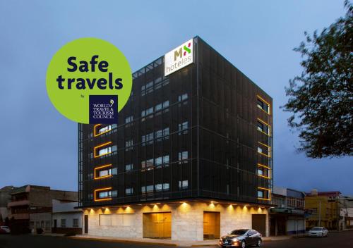 a building with a sign that reads safe travels at Hotel MX aeropuerto in Mexico City