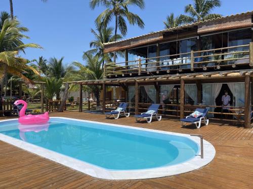 una piscina con un flamenco rosa frente a un edificio en Pousada Canto dos Encantos, en Barra Grande