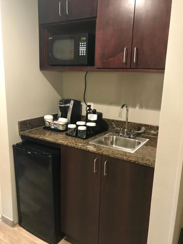 eine Küche mit einer Spüle und einer Mikrowelle in der Unterkunft Holiday Inn & Suites Albuquerque-North I-25, an IHG Hotel in Albuquerque