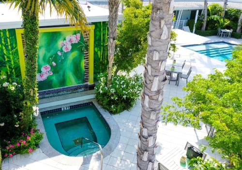 a swimming pool in the middle of a yard with a palm tree at Orchid Key Inn - Adults Only in Key West