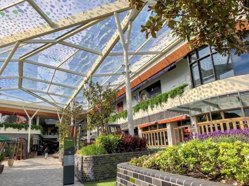 a glass conservatory in a shopping mall with plants at Skygarden Luxury Condo in Glen Waverley