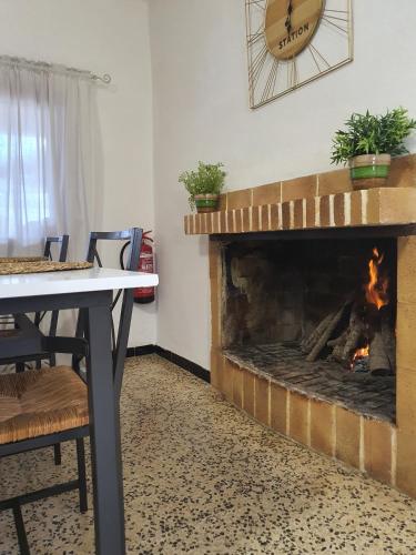 a fireplace in a room with a table and a clock at Eco Finca Sa Font Blava in Llucmajor