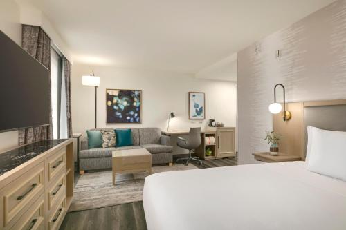 Habitación de hotel con cama y sala de estar. en Hyatt Place Santa Barbara, en Santa Bárbara