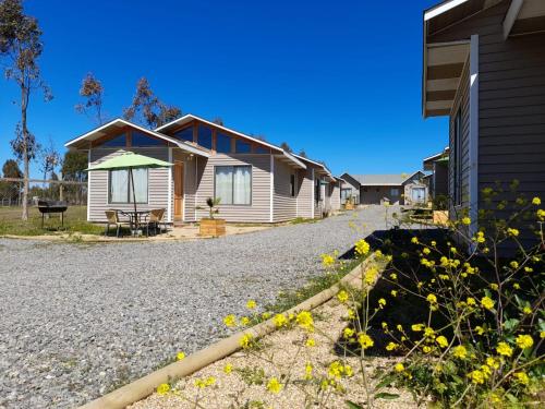 a house with a gravel driveway next to a house at Cabañas Costa las Dichas in Algarrobo