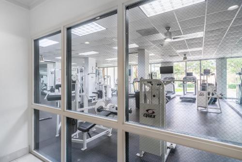 a gym with treadmills and machines and windows at Sunny Isles Ocean Reserve Condo Apartments in Miami Beach