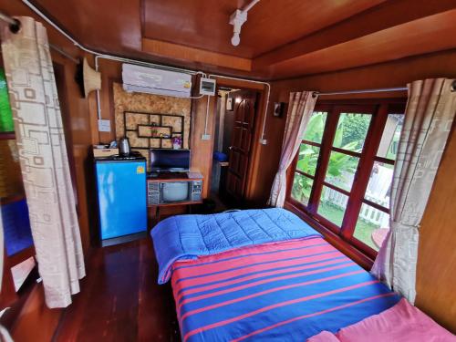 a bed in the back of a train room at ข้าวทุ่งเบ็ญจาโฮมสเตย์ in Ban Hat Phang