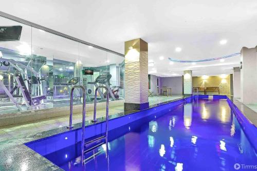 a gym with a swimming pool in a hotel at 96 North Terrace Spa Apartment in Adelaide