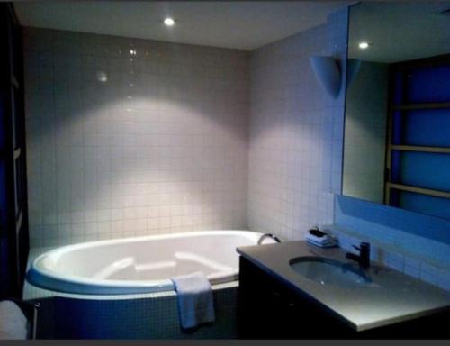a bathroom with a tub and a sink at 96 North Terrace Spa Apartment in Adelaide