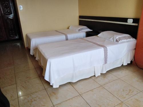 2 letti posti uno accanto all'altro in una stanza di Hotel Saint Paul 01 Flat a Manaus