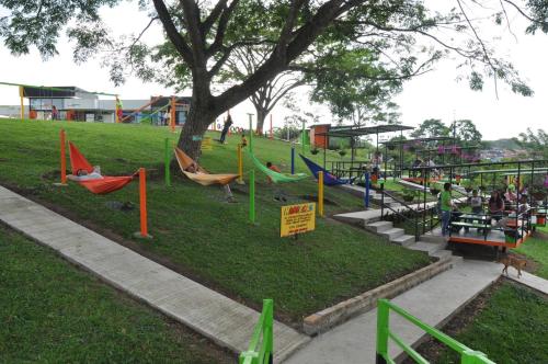a park with a playground with swings and a tree at Glamping - Calochorno in Alcalá