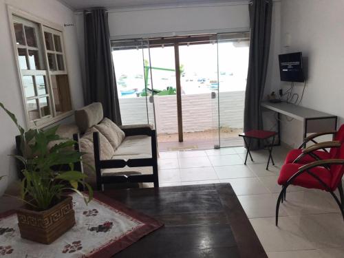 ein Wohnzimmer mit einem Sofa und einem Tisch in der Unterkunft Casa de praia Ponta dos Ganchos de Fora in Governador Celso Ramos