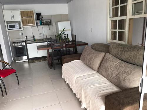 ein Wohnzimmer mit einem Sofa und einer Küche in der Unterkunft Casa de praia Ponta dos Ganchos de Fora in Governador Celso Ramos