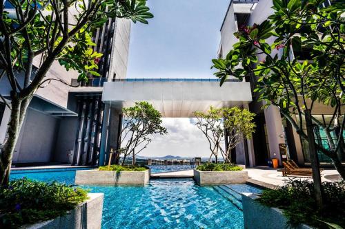 a swimming pool in the middle of a building with trees at Imperio Residences Private Bathtub or Jacuzzi by Nestcove in Melaka