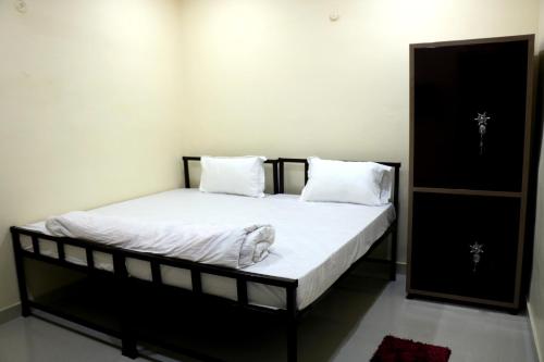 a bedroom with a bed with white sheets and pillows at Saraswati Palace in Varanasi