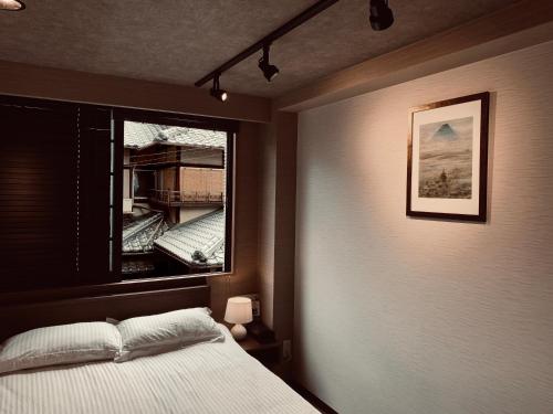 a bedroom with a bed and a window at Hotel Traveling Bridge Nijojo in Kyoto