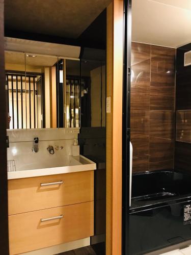 a bathroom with a sink and a bath tub at Hotel Traveling Bridge Nijojo in Kyoto