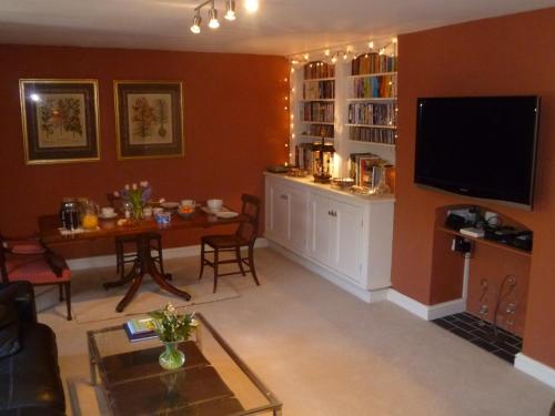 a living room with a table and a tv at Laurel House in Cheltenham