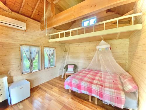 ein Schlafzimmer mit einem Bett in einer Holzhütte in der Unterkunft イリワ -stay&coffee iriwa- in Ishigaki-jima