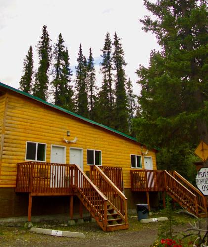 a yellow building with two decks on it at Carlo Creek Cabins in McKinley Park