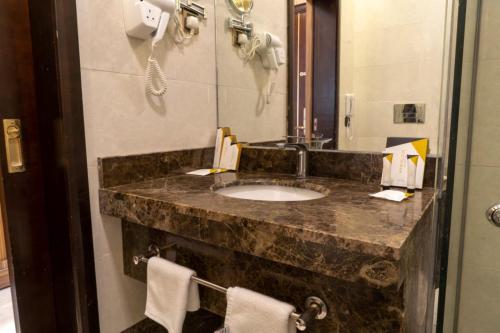 a bathroom with a sink and a mirror at Golden Tower Hotel AlKhobar Corniche in Al Khobar