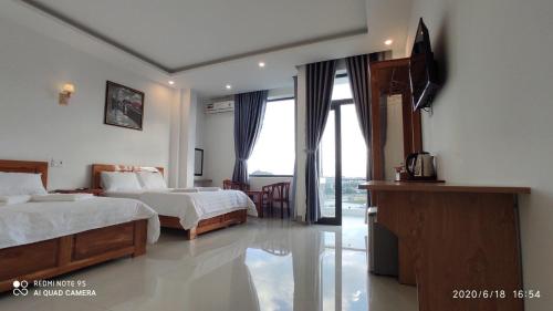 a hotel room with two beds and a television at Queen Hotel in Tuy Hoa