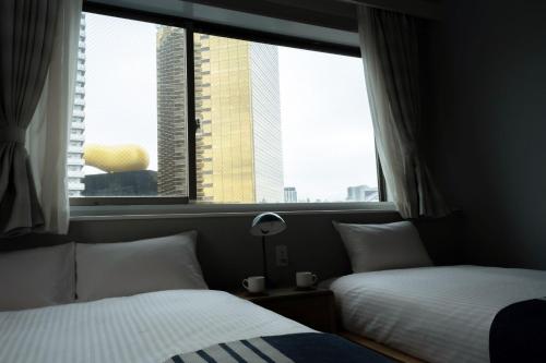 Ένα ή περισσότερα κρεβάτια σε δωμάτιο στο Playsis East Tokyo