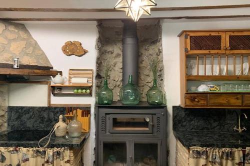 蓬托內斯的住宿－Molino Elidio，厨房配有带绿色玻璃花瓶的炉灶