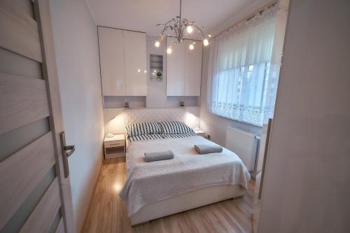 a bedroom with a large bed and a window at Apartament Willa Ogrodowa 18 in Polanica-Zdrój