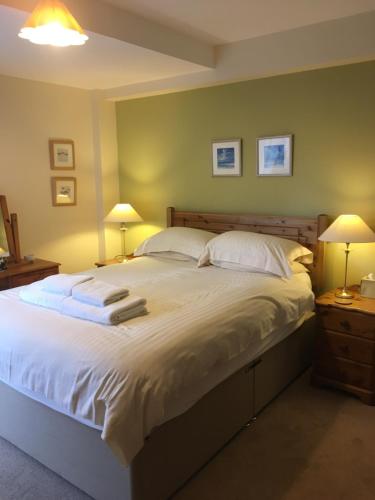 a bedroom with a large white bed with two lamps at 1/5 Lismore House in Oban