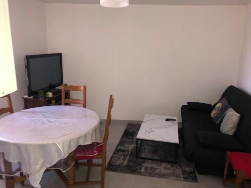 un salon avec une table et un canapé dans l'établissement Gîte Luna, à Sablet