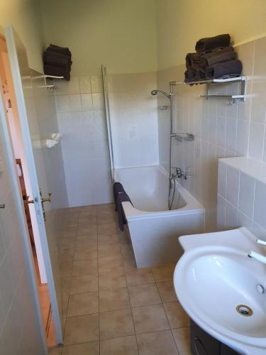 a bathroom with a sink and a tub and a toilet at Apartmenthaus Am Schlosspark in Schkopau