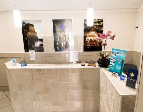 a counter in a store with posters and flowers at Hotel Colombo in Naples